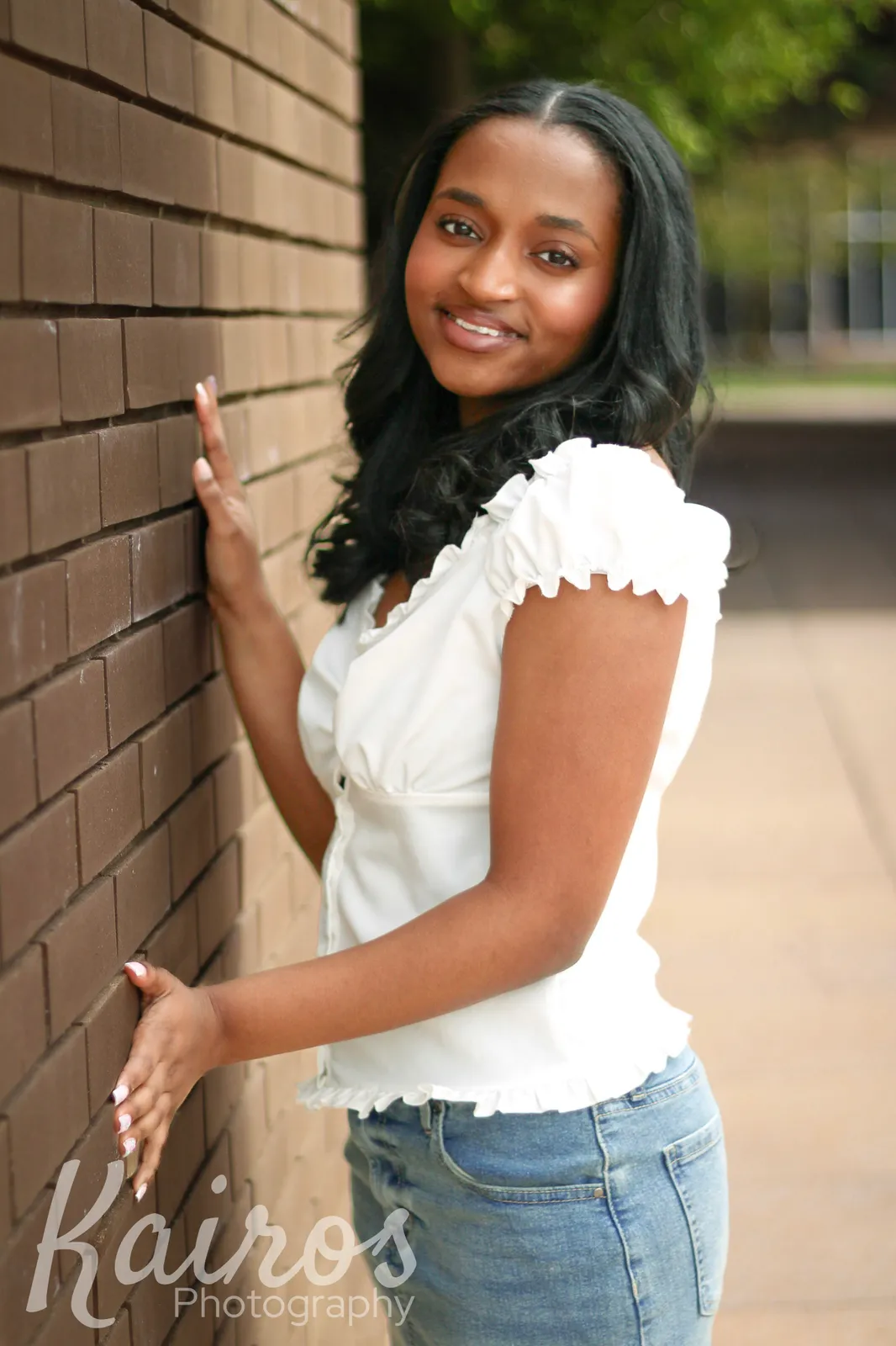 Camryn senior portrait by brick wall