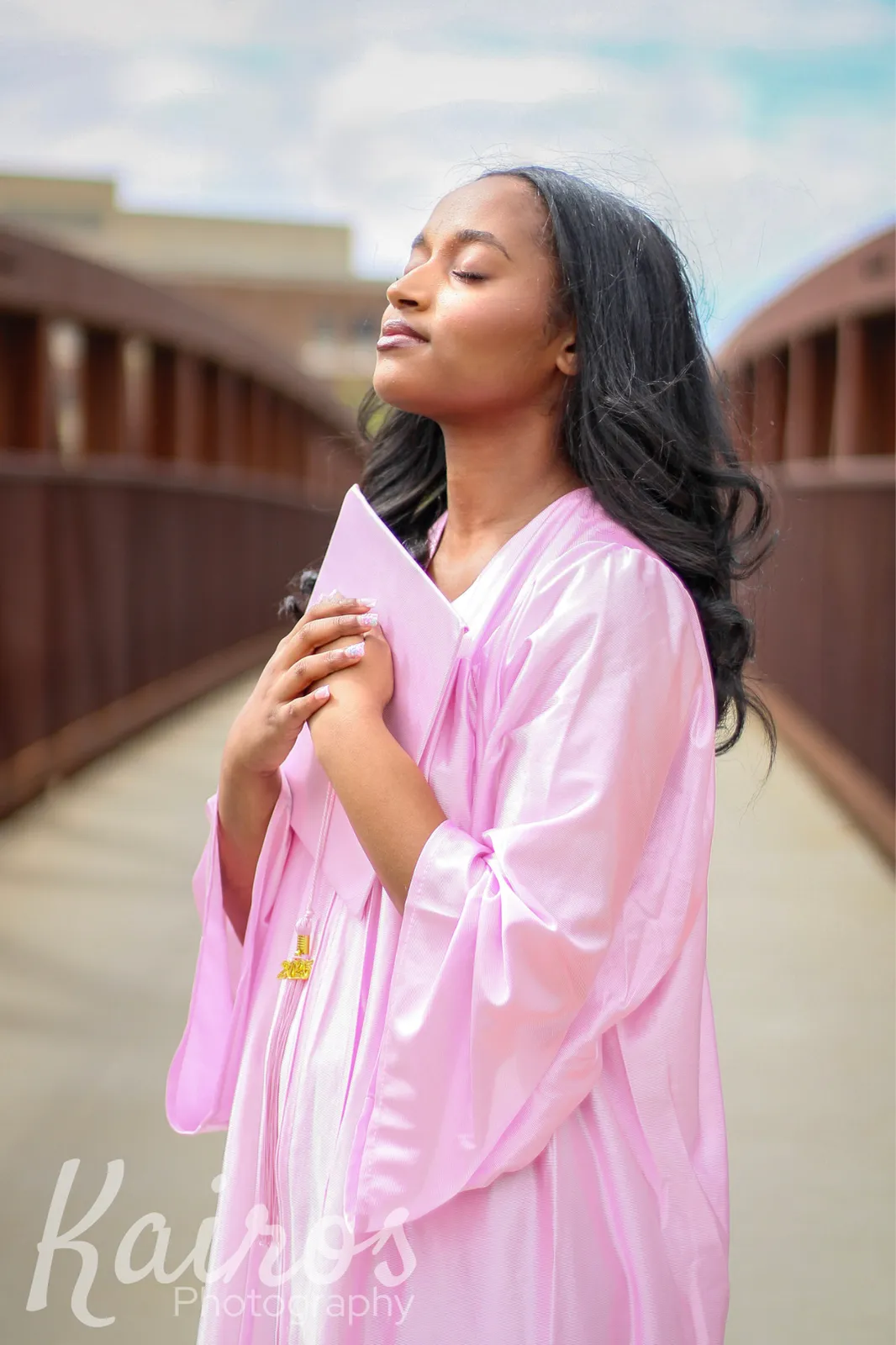 Camryn senior portrait holding cap in pink gown