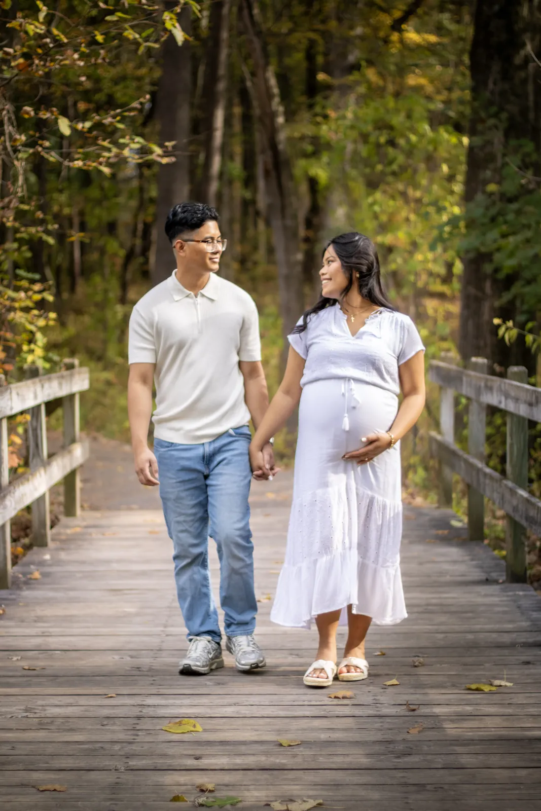 Marianne Fall Pictorials expecting parents walking on wooden path